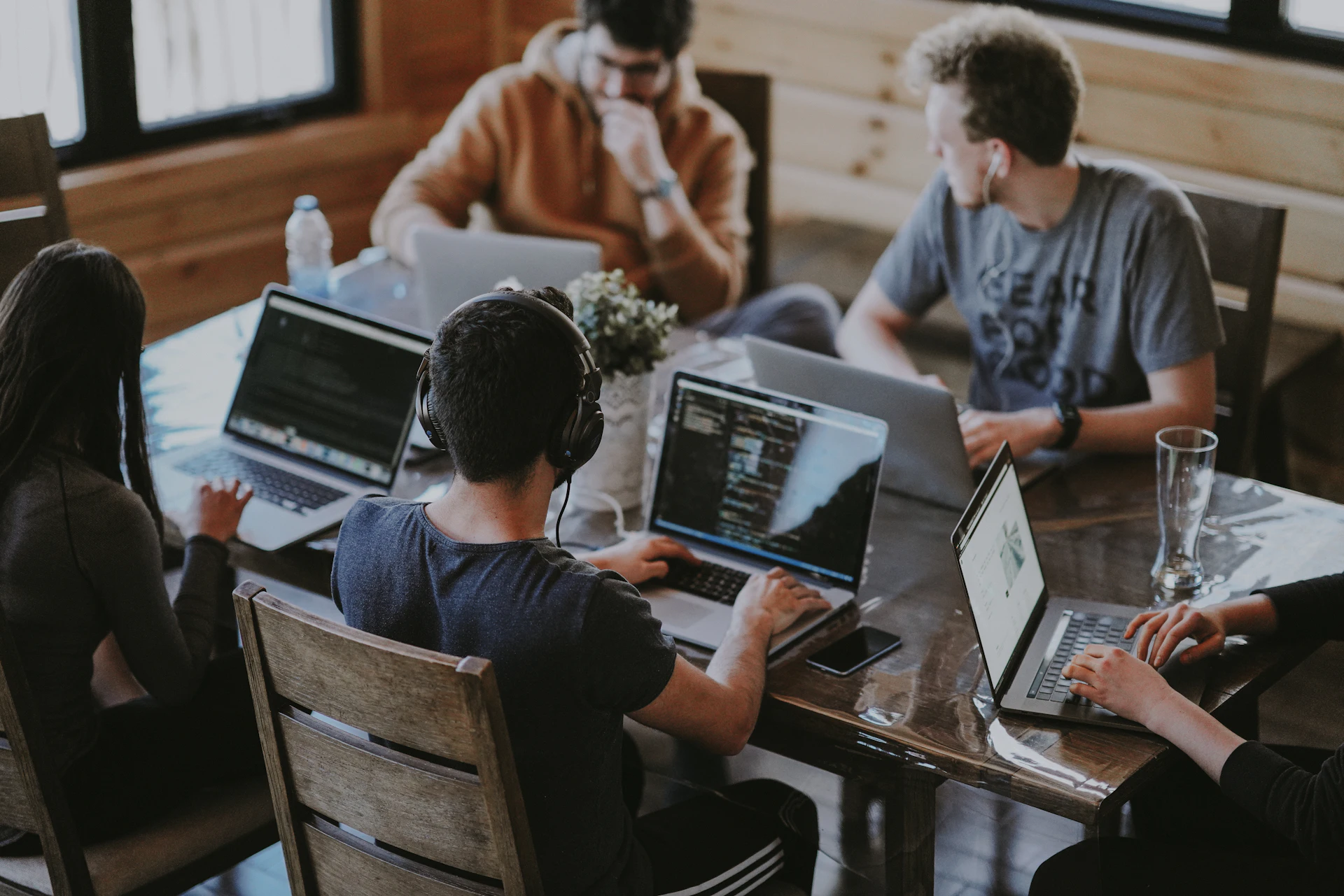 A team working together around a shared table, laptops open